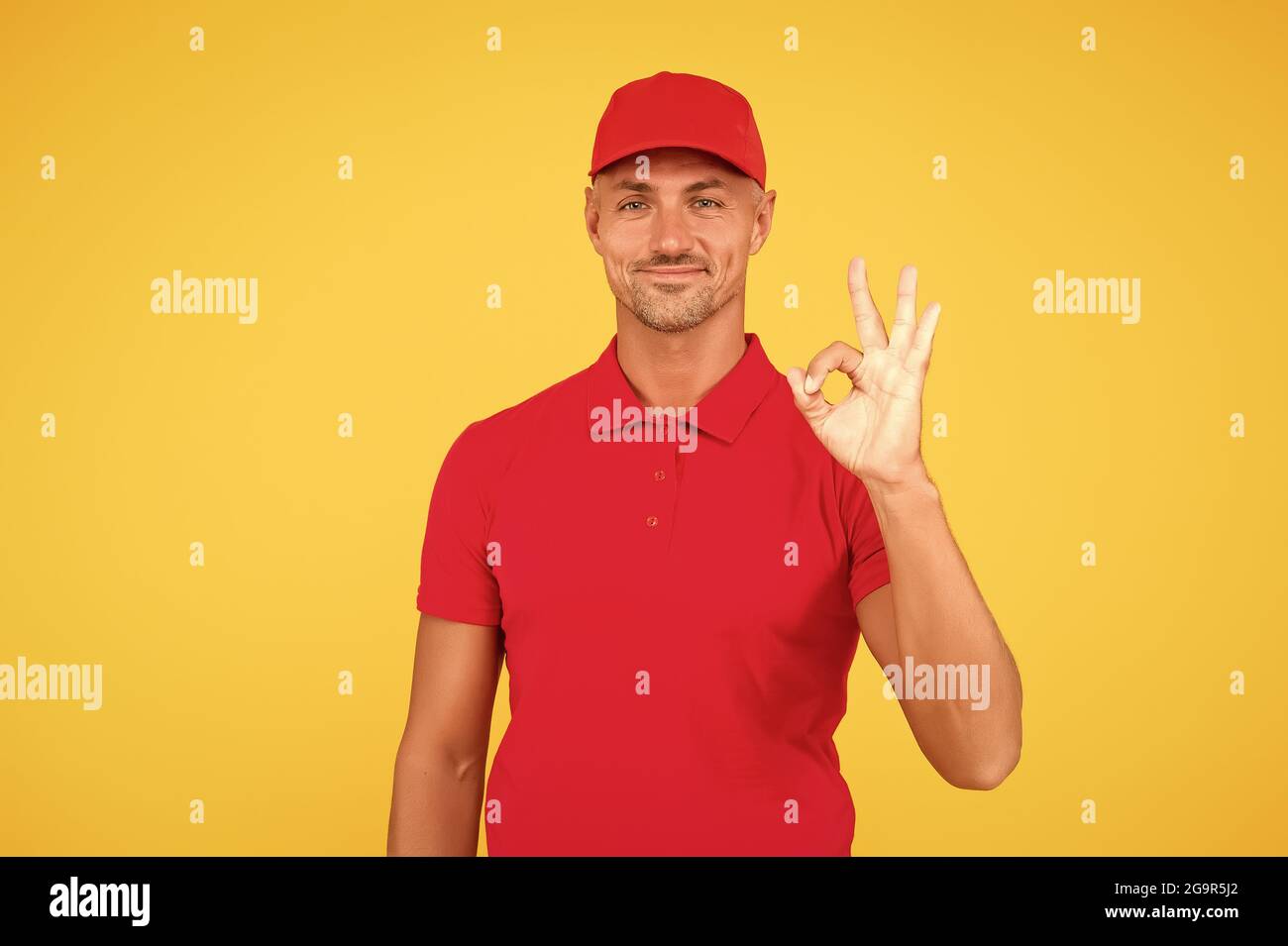 Free services. Freight transportation. Perfect delivery. Delivery man yellow background. Express delivery courier service. Parcel post package Stock Photo