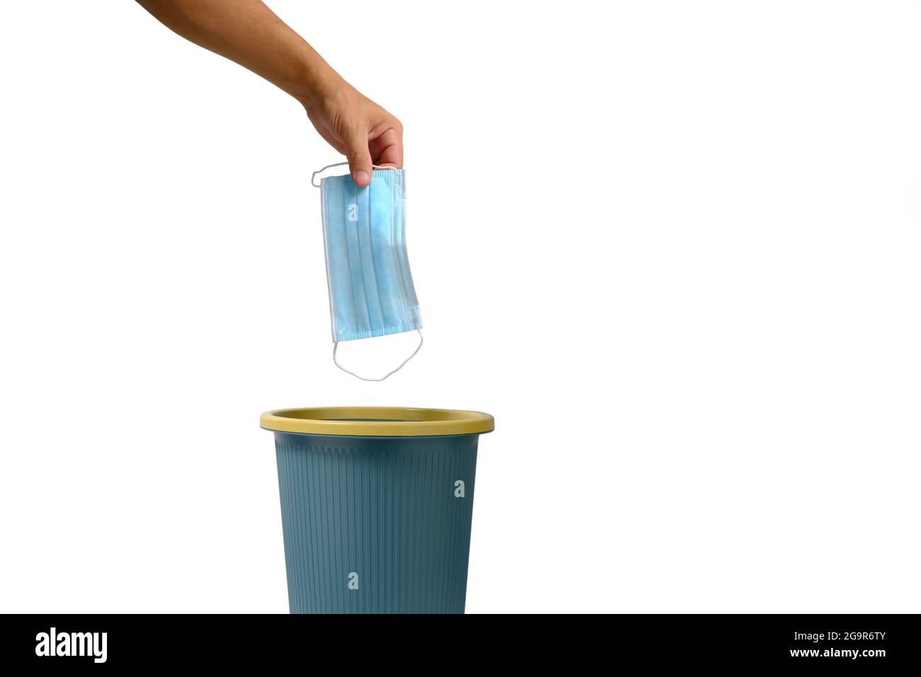 Hand on white background throws medical mask into trash.Relaxation of