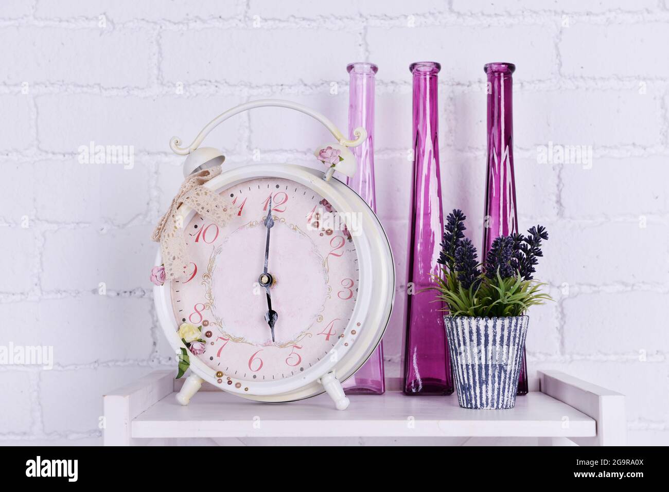 Interior design on tabletop with alarm clock, plant and decorative