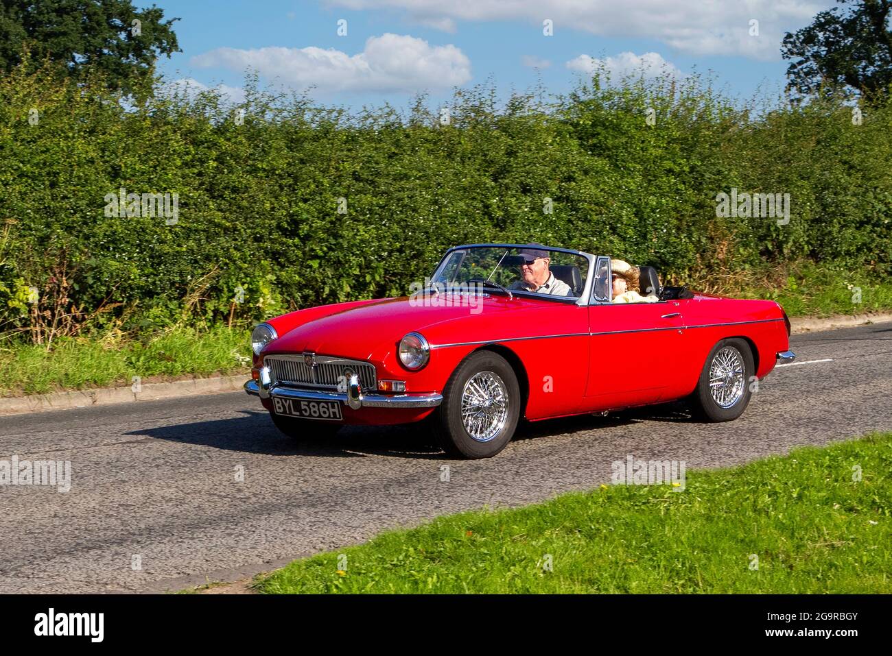 1970 70s red MGB british sports car vehicle en-route to Capesthorne Hall classic July car show, Cheshire, UK Stock Photo