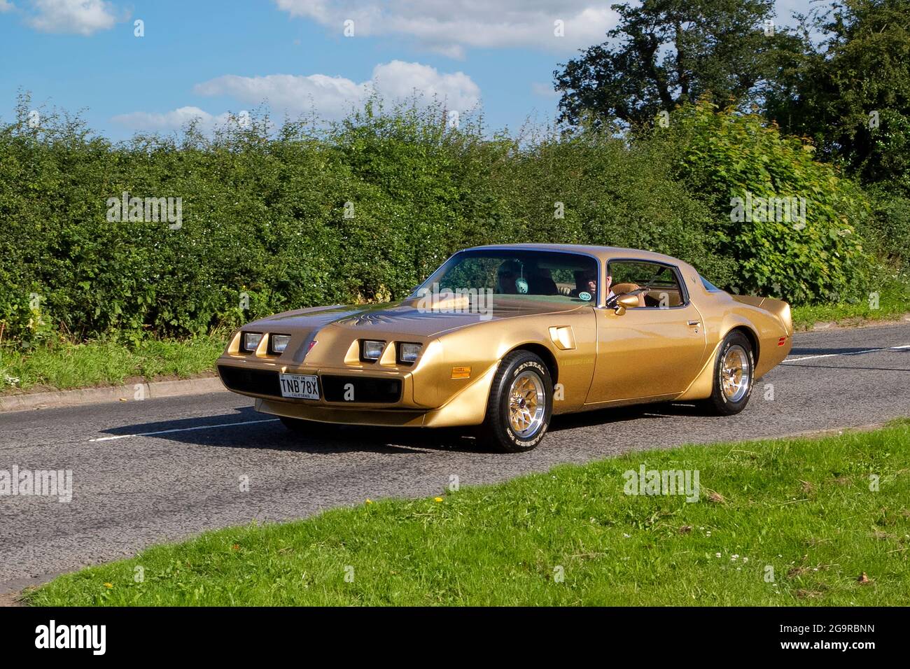 1979 70s gold Pontiac Firebird 6590cc petrol vehicle en-route to Capesthorne Hall classic July car show, Cheshire, UK Stock Photo