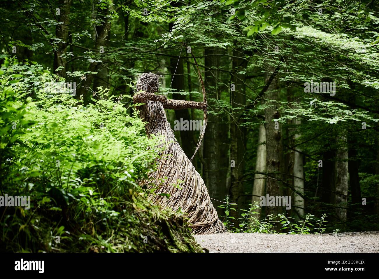 A thatch sculpture of a woman holding a bow and arrow outside Skipton Castle in Yorkshire Stock Photo