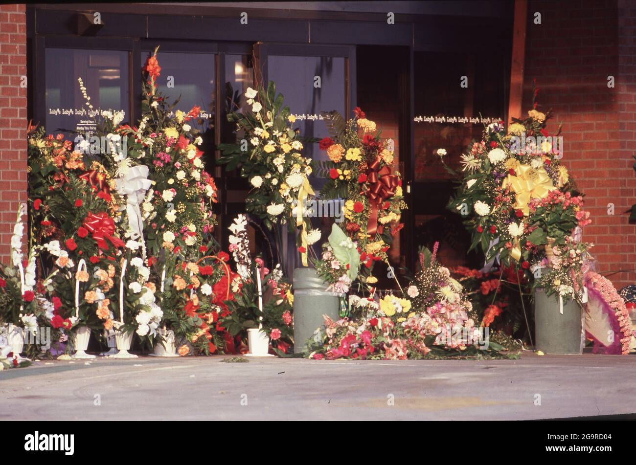 Killeen Texas USA, October 1991: Community members leave flowers in memory of the victims of a mass shooting at Luby's Cafeteria in Killeen. on October 16. George Hennard, a 35-year-old Killeen resident, crashed a pickup into the eatery and shot 23 lunch-time diners and staff to death before killing himself. ©Bob Daemmrich Stock Photo