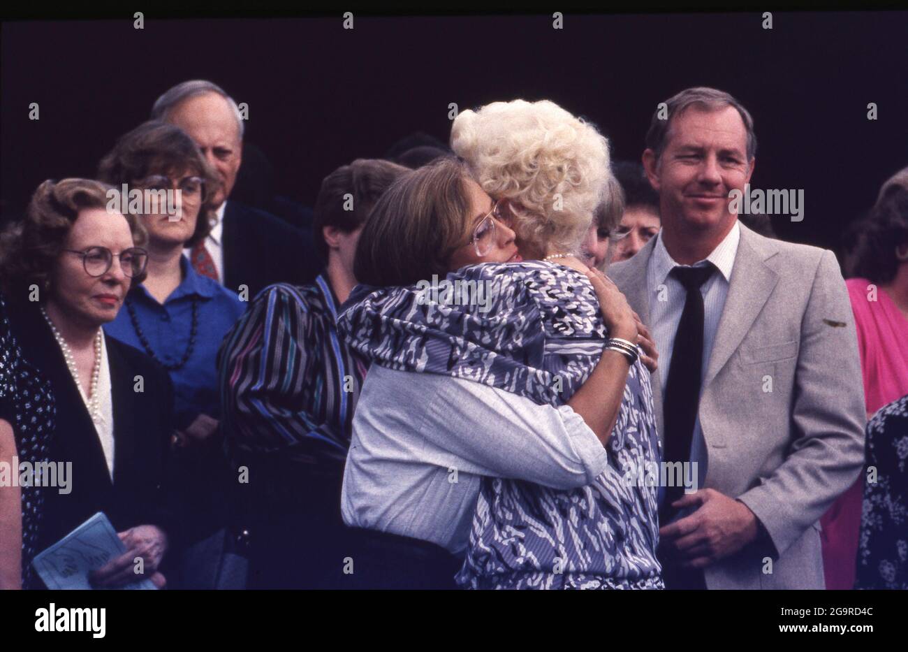 Killeen Texas USA, October 1991: Mourners embrace after a funeral service for one of the victims of a mass shooting at Luby's Cafeteria in Killeen. on October 16. George Hennard, a 35-year-old Killeen resident, crashed a pickup into the eatery and shot 23 people to death before killing himself. ©Bob Daemmrich Stock Photo