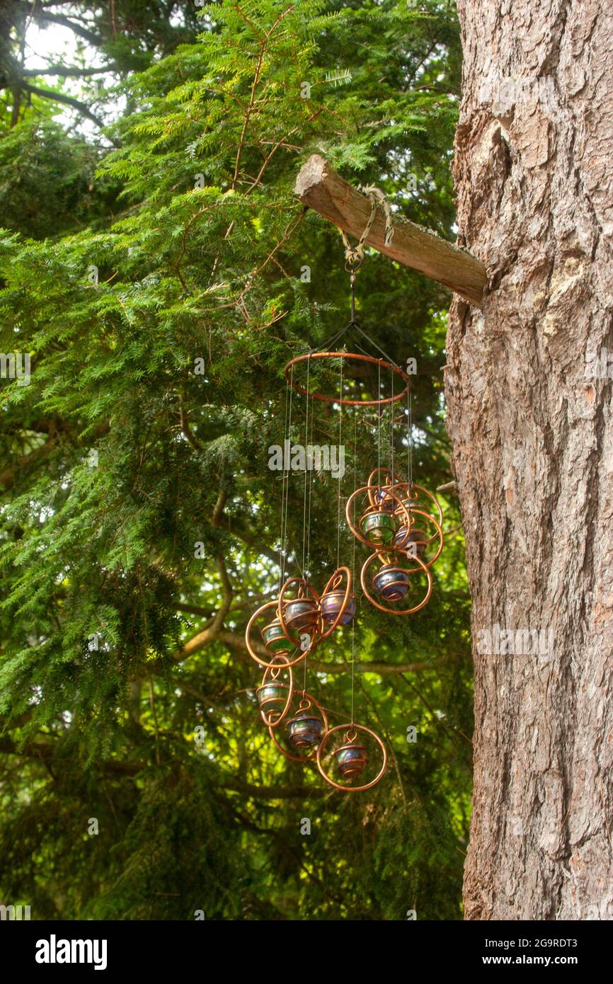 Artistic wind chimes hanging from a tree in Muskoka, Ontario Stock Photo