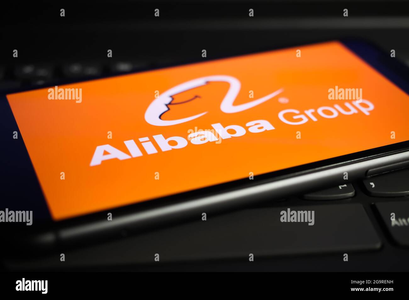 Viersen, Germany - June 1. 2021: Closeup of mobile phone screen with logo lettering of alibaba on computer keyboard Stock Photo