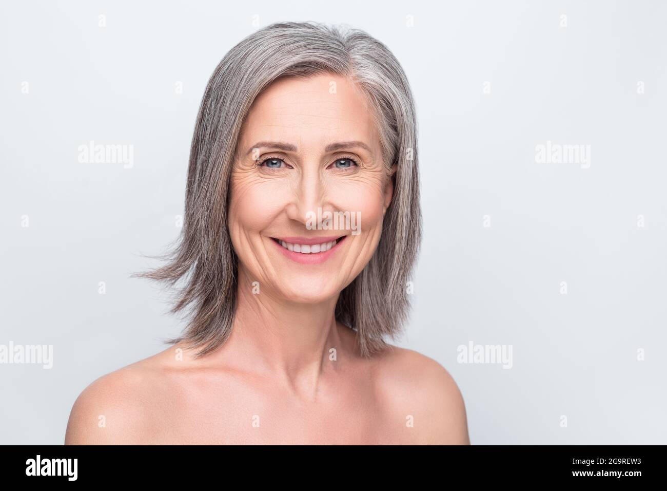 Portrait of attractive cheerful middle-aged woman collagen botox lifting effect isolated over gray pastel color background Stock Photo