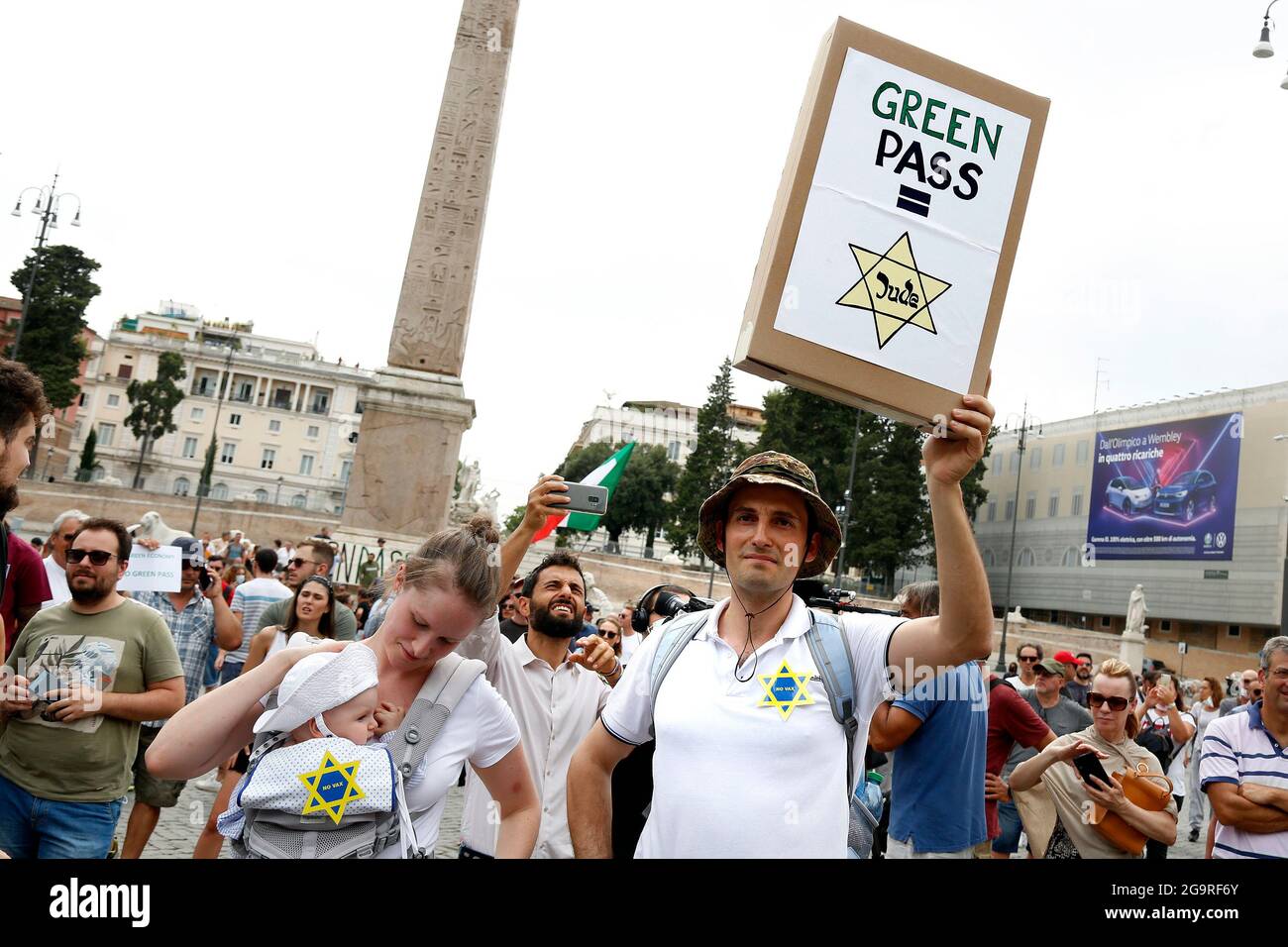 Rome, Italy. 27th July, 2021. A man with his wife and child, shows a banner that symbolize that the Green pass is like the David star sewn on the clothes of the jews in nazi-fascism times, during the demonstration against the green pass, that certifies the vaccination against covid 19, after the last decree of the council of ministers, necessary to enter public places, such as offices, schools but also restaurants.Rome (Italy), July 27th 2021 Photo Samantha Zucchi Insidefoto Credit: insidefoto srl/Alamy Live News Stock Photo