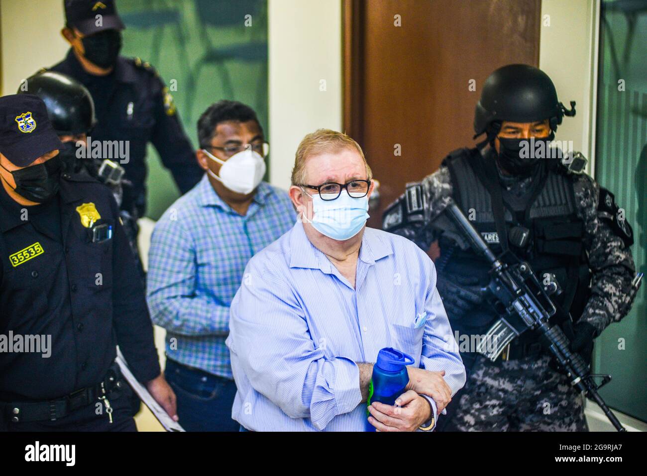 Police officers from a tactical unit escort former Minister of 