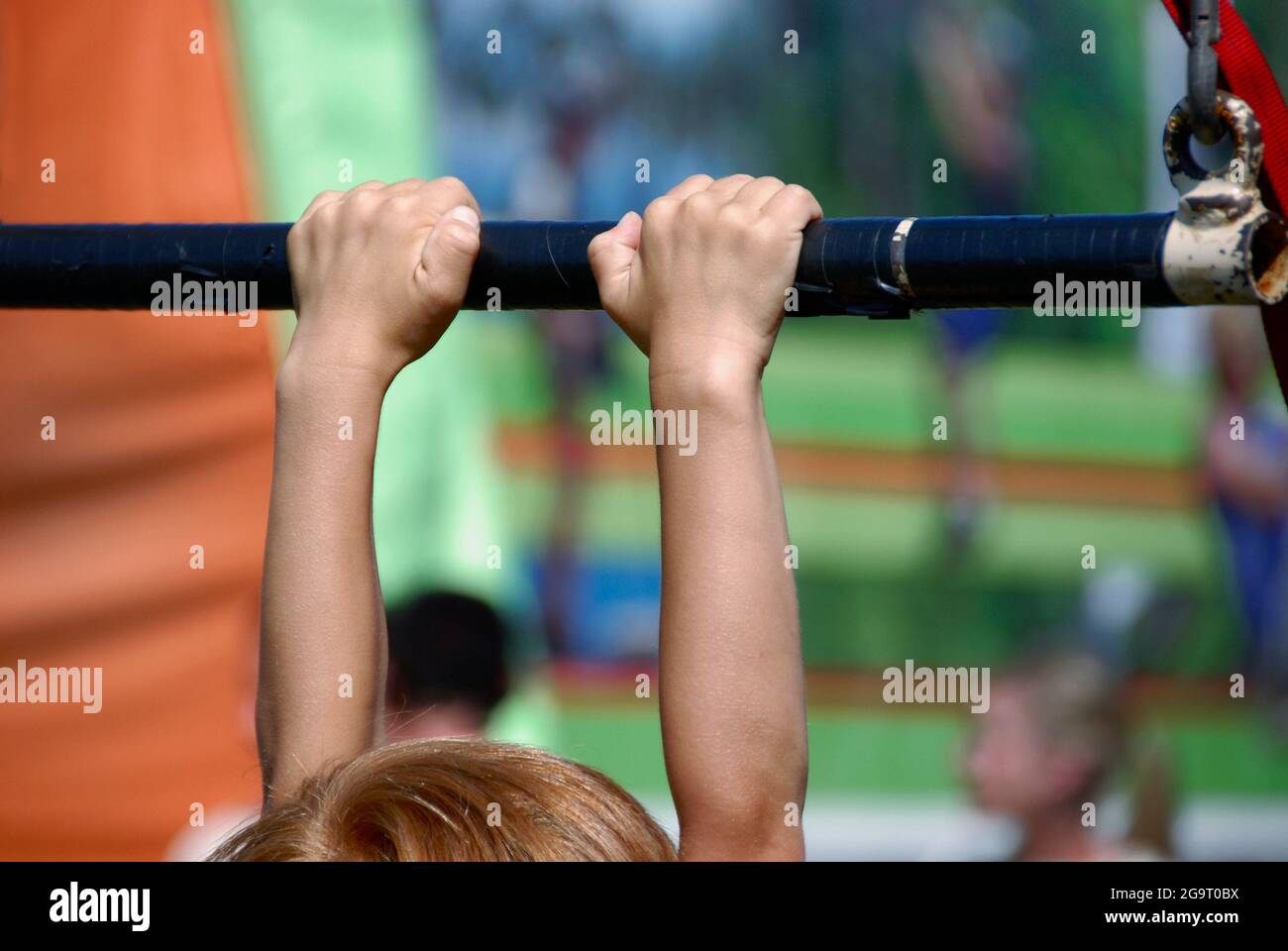 Active youth: Child using a pull up bar. Stock Photo