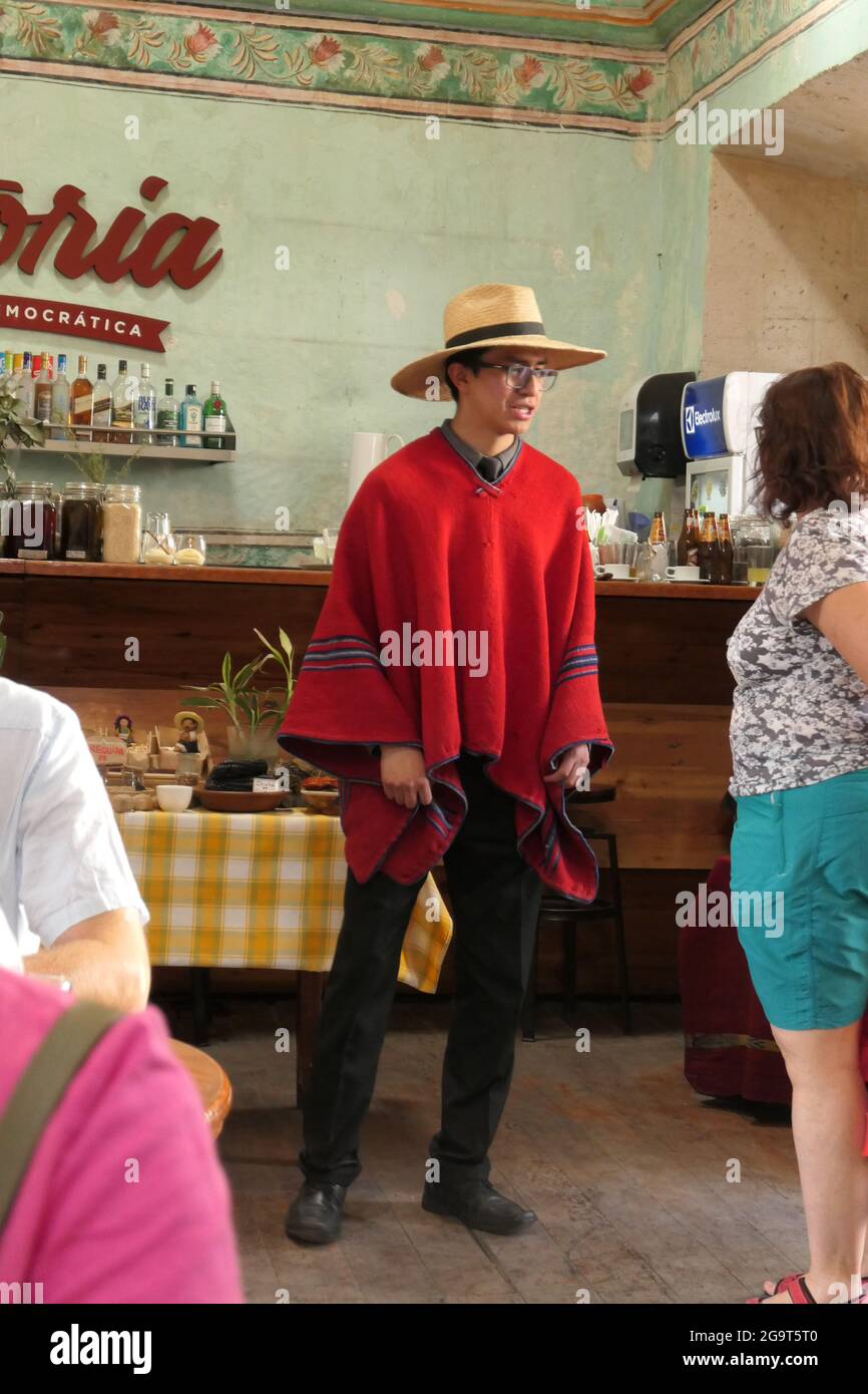 Waiter in Peru Restaurant called Victoria in Arequipa hat poncho style cape  help helping serve serving service glasses alcohol shelf old type cloak  Stock Photo - Alamy