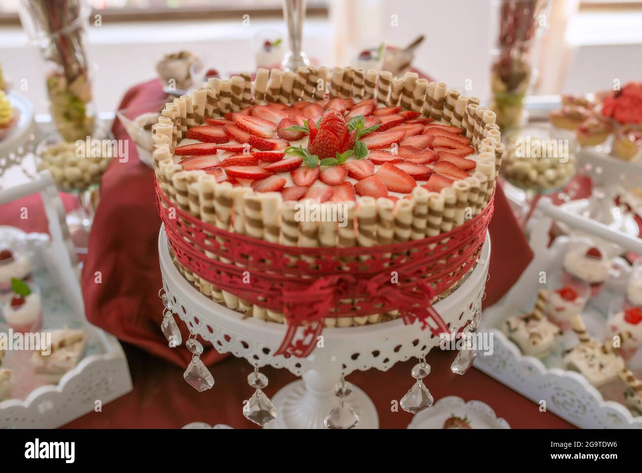Delicious strawberry cheesecake, centerpiece at an event, birthday or wedding reception, decadent dessert decorated with thin strawberry slices Stock Photo