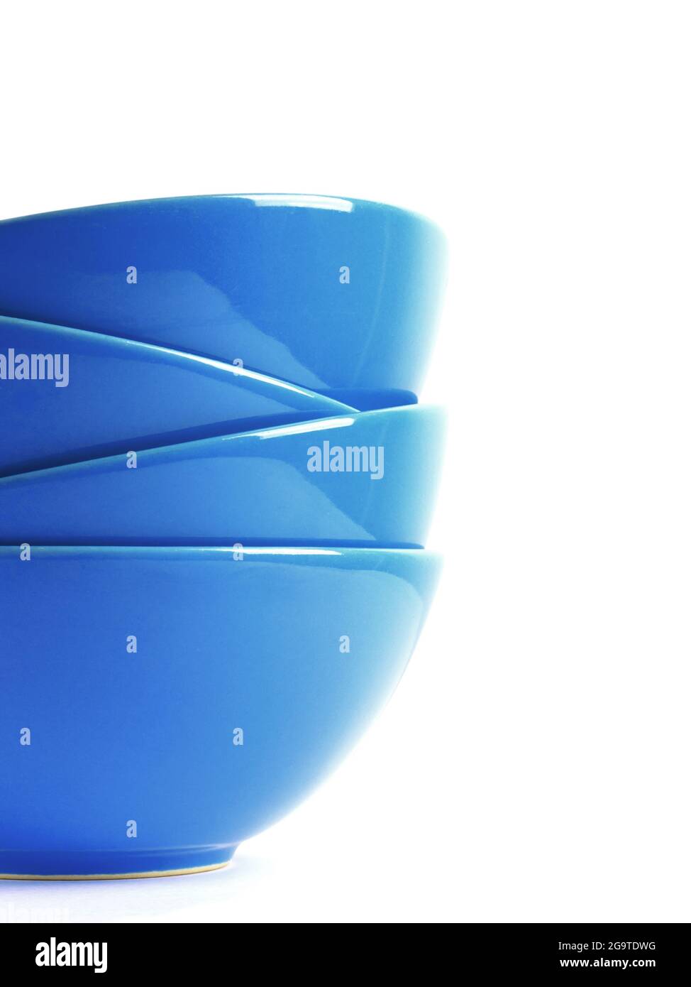 Stack of four blue ceramic bowls isolated on white. Close up shot. Stock Photo