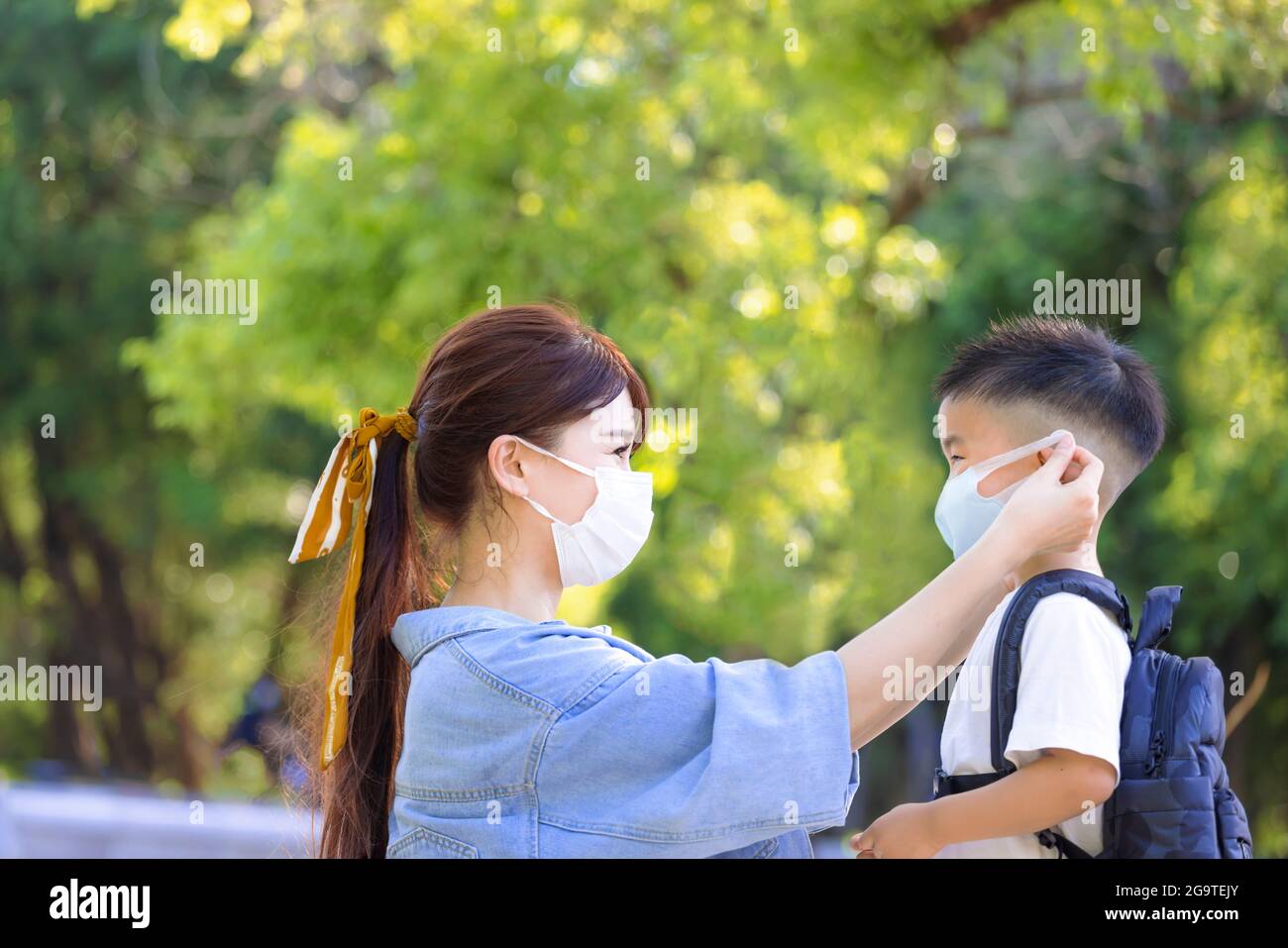 Mother help her son wearing medical mask for protection Stock Photo