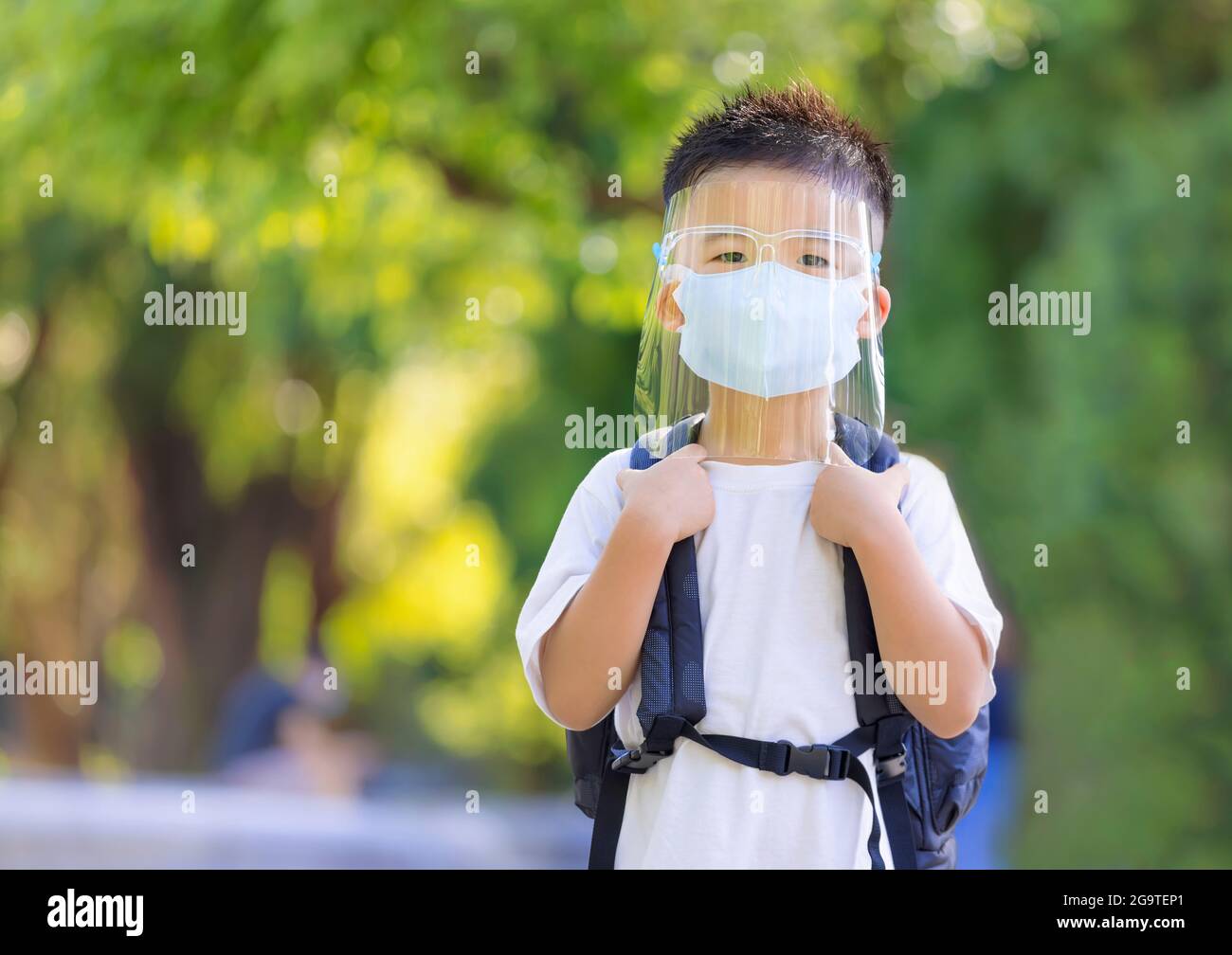 Happy kid  wearing mask and face shield  to protection Stock Photo