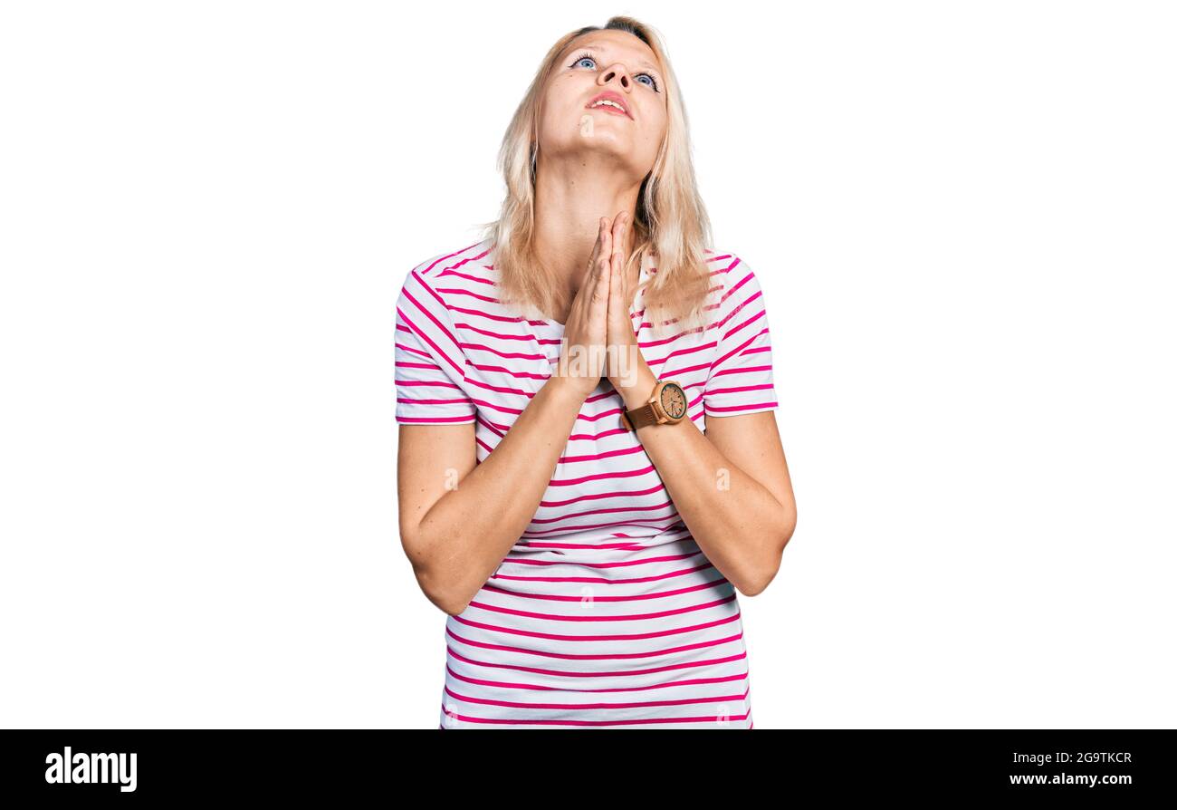 Young caucasian woman wearing casual clothes begging and praying with ...