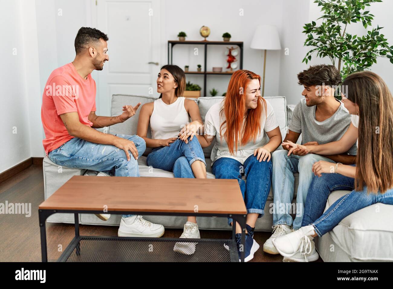 Group of young friends smiling happy sitting on the sofa at home Stock ...