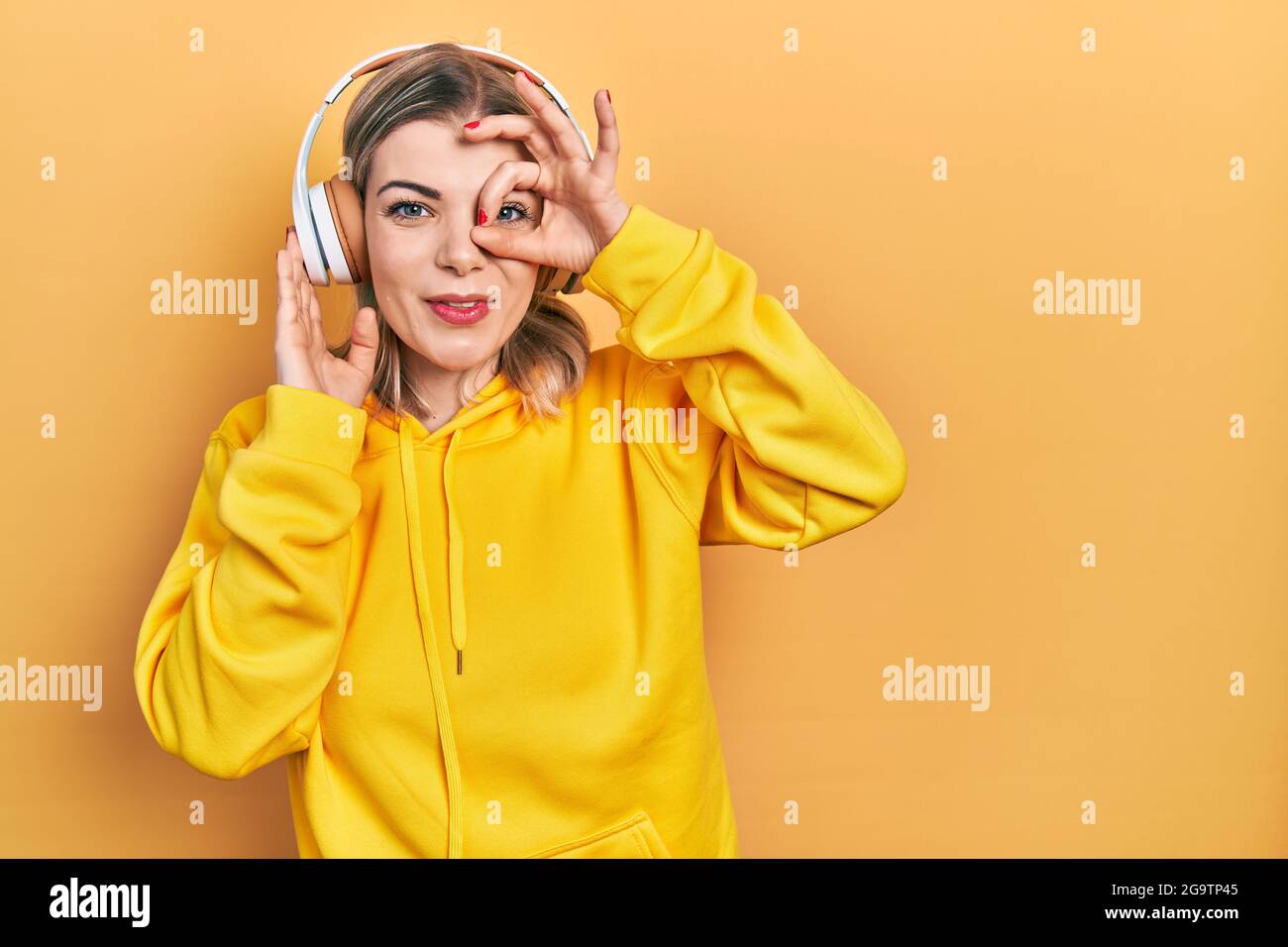 Beautiful caucasian woman listening to music using headphones smiling ...