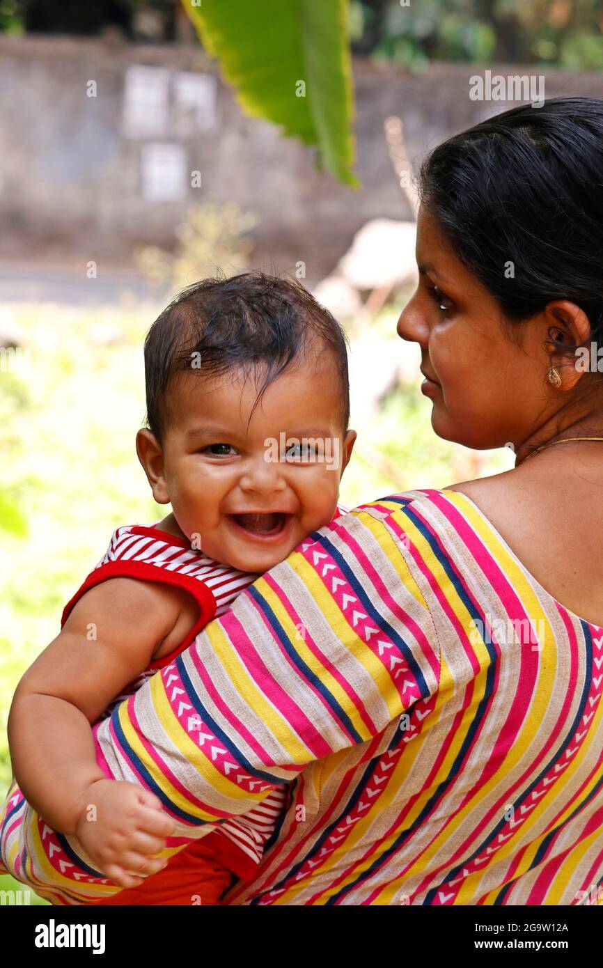 mother holding an indian cute baby boy with smile Stock Photo - Alamy