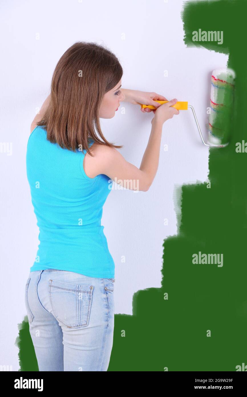 Beautiful girl paints wall in room Stock Photo Alamy
