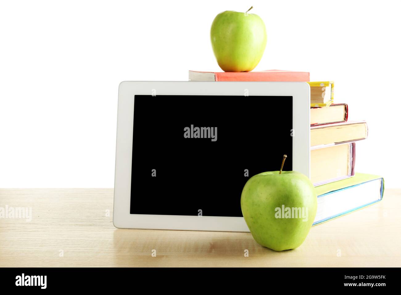 Books, PC tablet and apple on desk, isolated on white Stock Photo Alamy