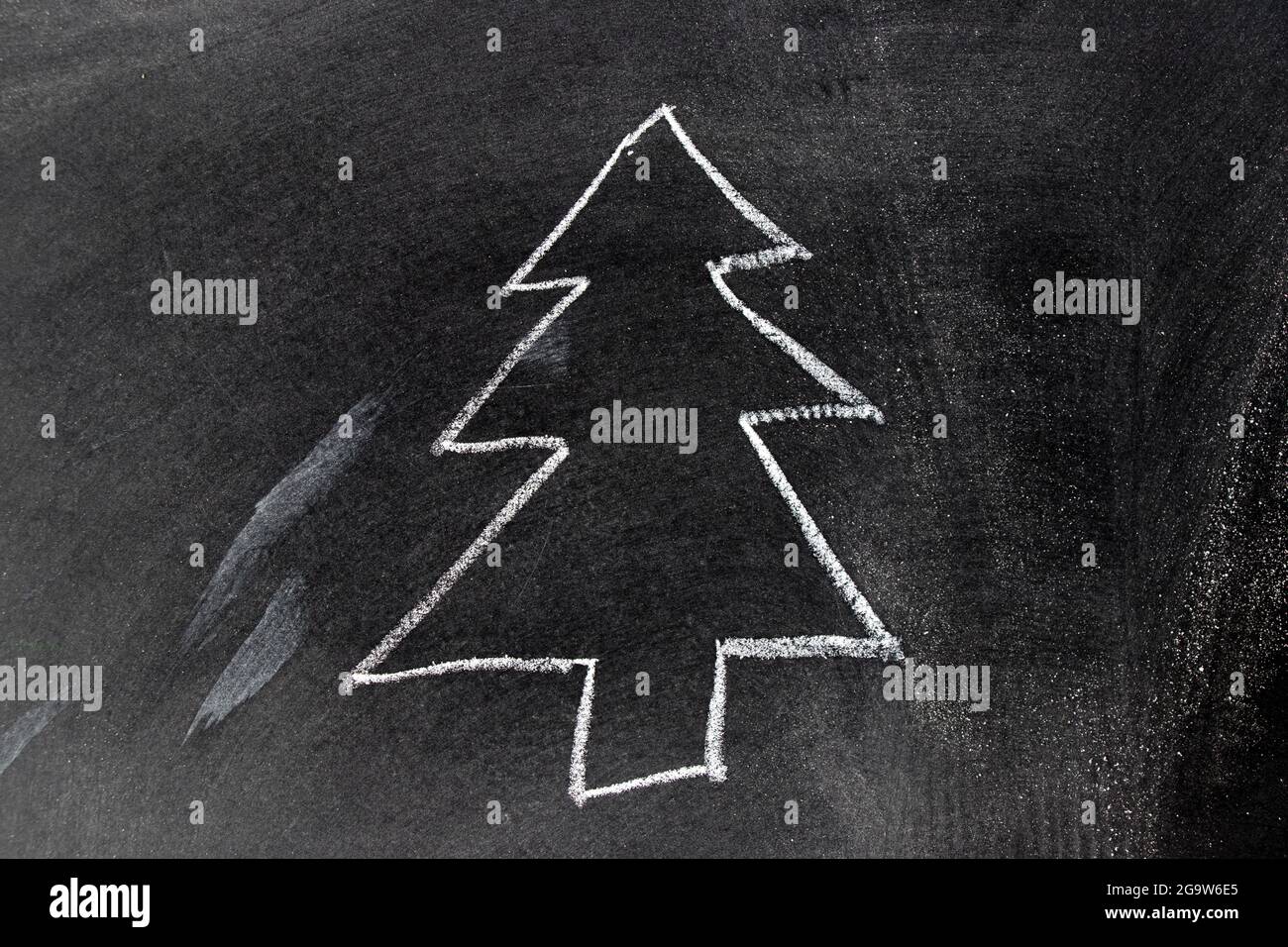 White chalk hand drawing in christmas or pine tree shape on blackboard ...