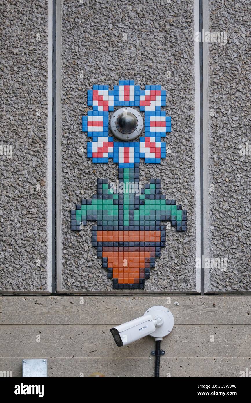 A CCTV camera is incorporated into a quirky flower and flowerpot mosaic design. Stock Photo