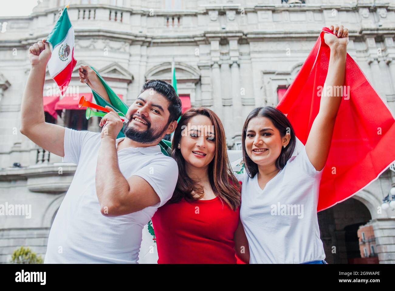 Group of mexican soccer fans holding flags and trumpets in Mexico City Stock Photo