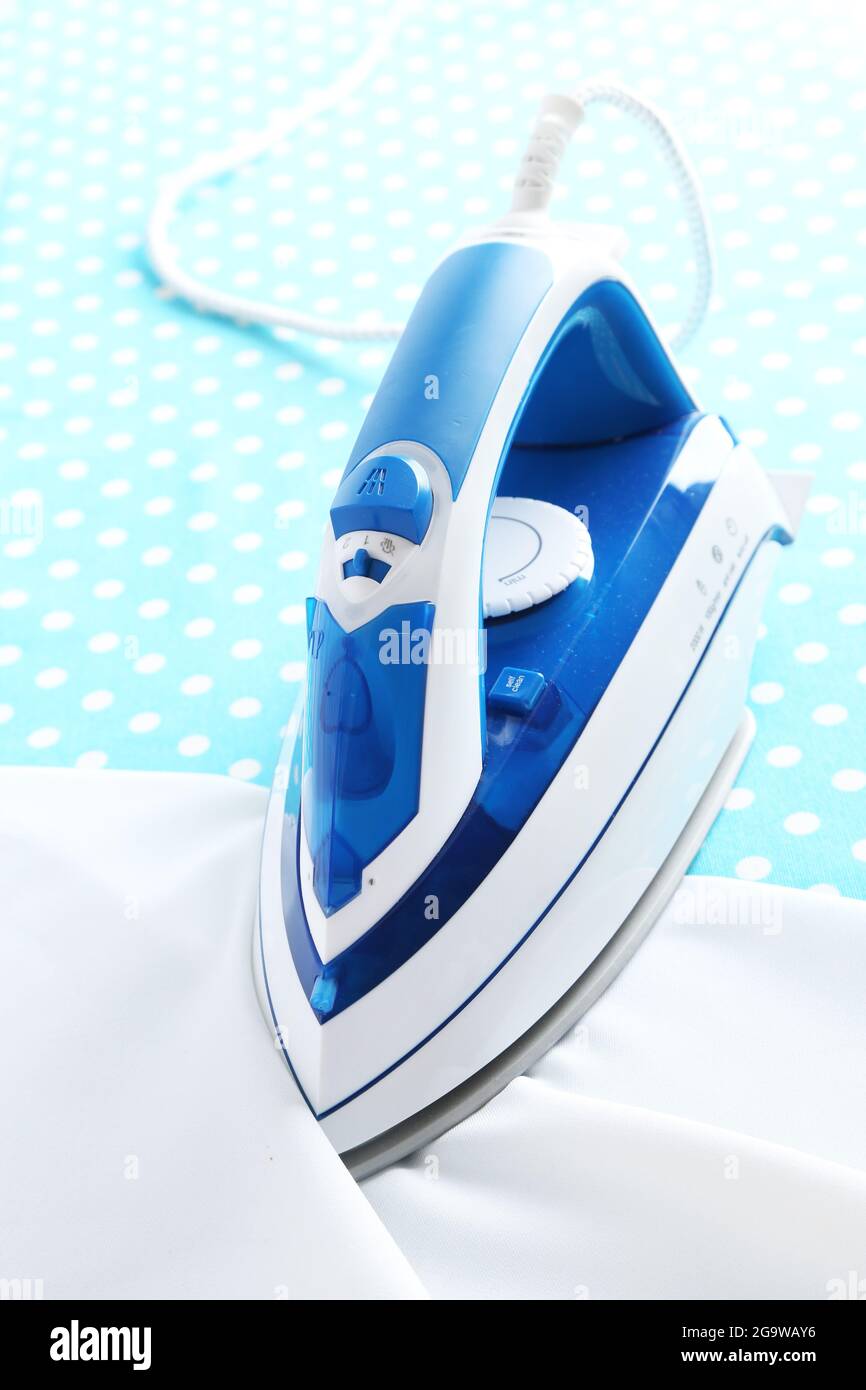 Iron on ironing board closeup Stock Photo Alamy
