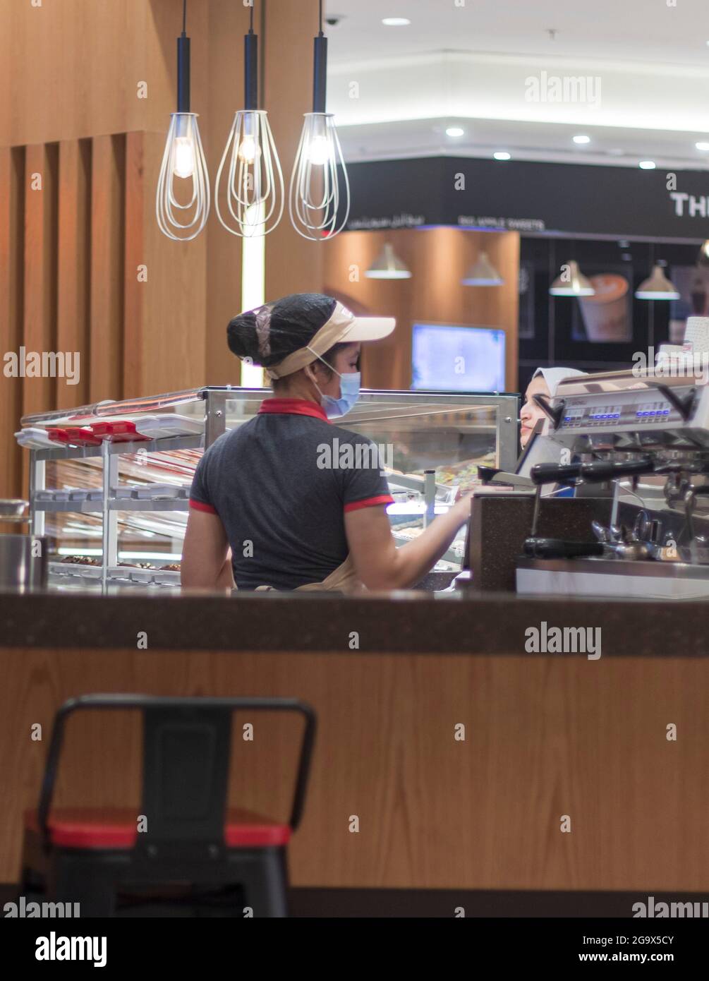 Dubai, UAE - 07.17.2021 -Shot of a barista serving customer in Dubai mall Stock Photo