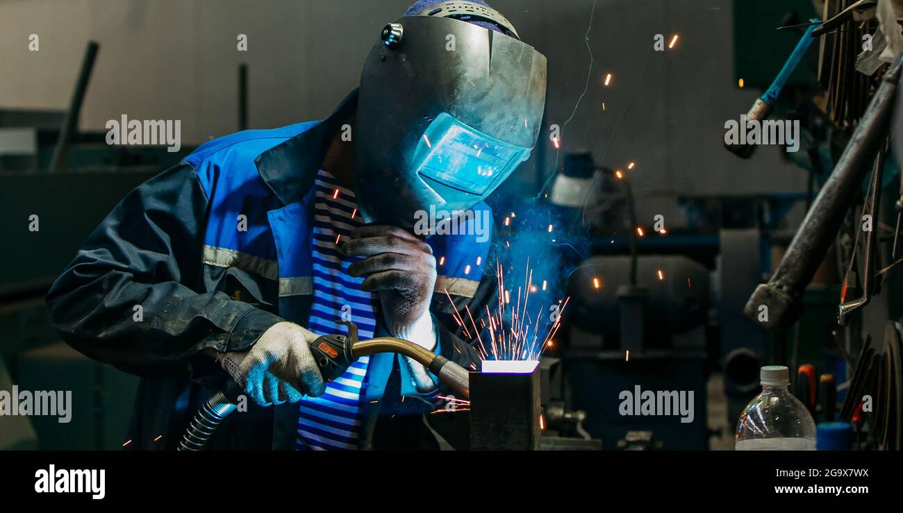 Welder working with electrode at semiautomatic arc welding Stock Photo