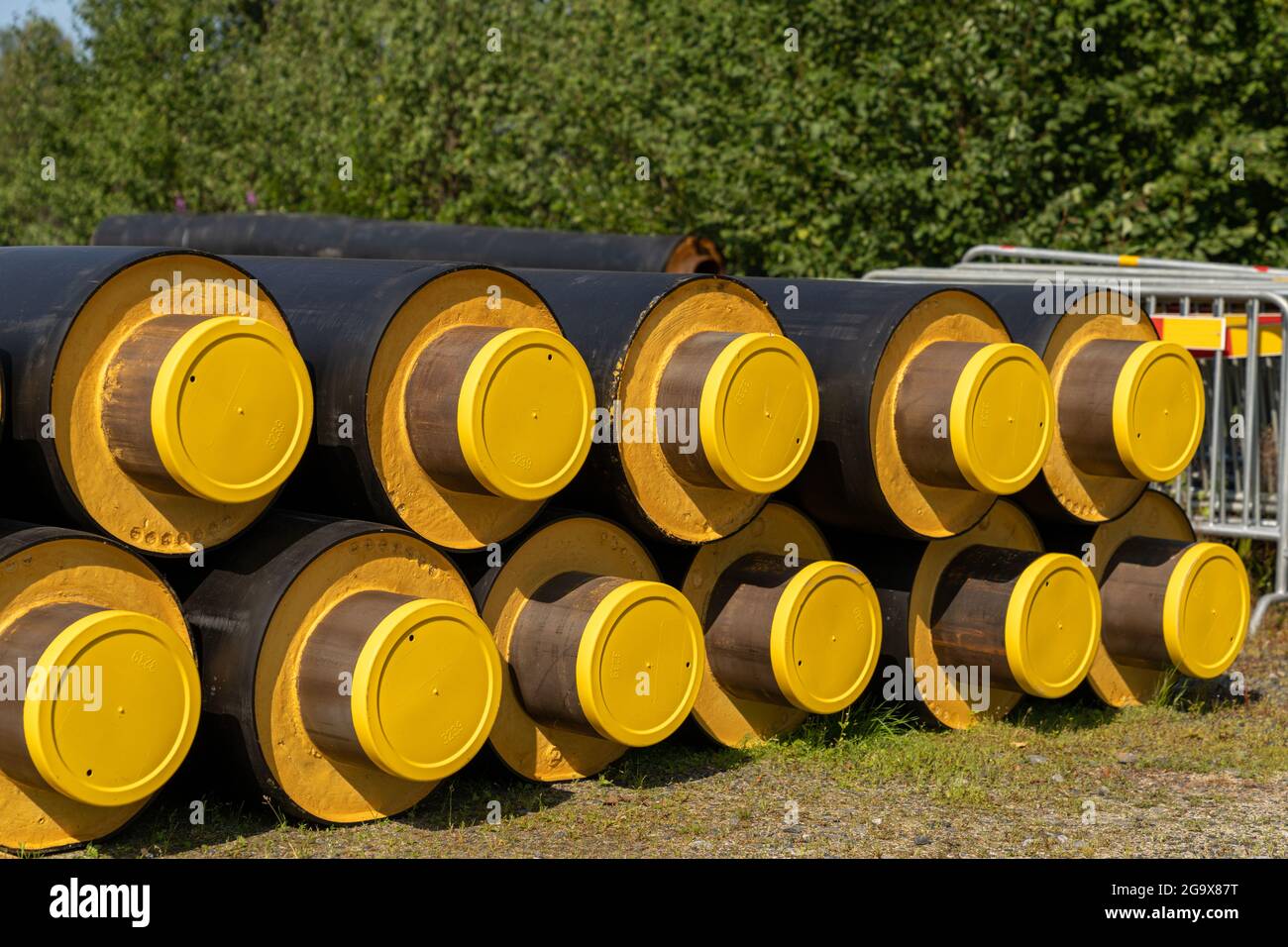 A close up view of a stack of large industrial water pipes with thick insulation covering for building in cold regions Stock Photo