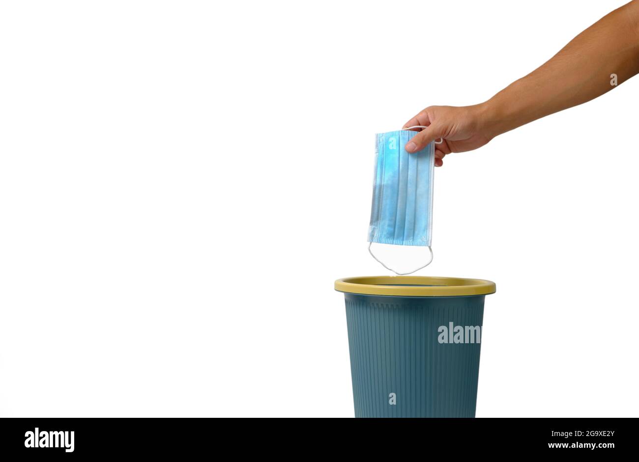 Hand on white background throws medical mask into trash.Relaxation of