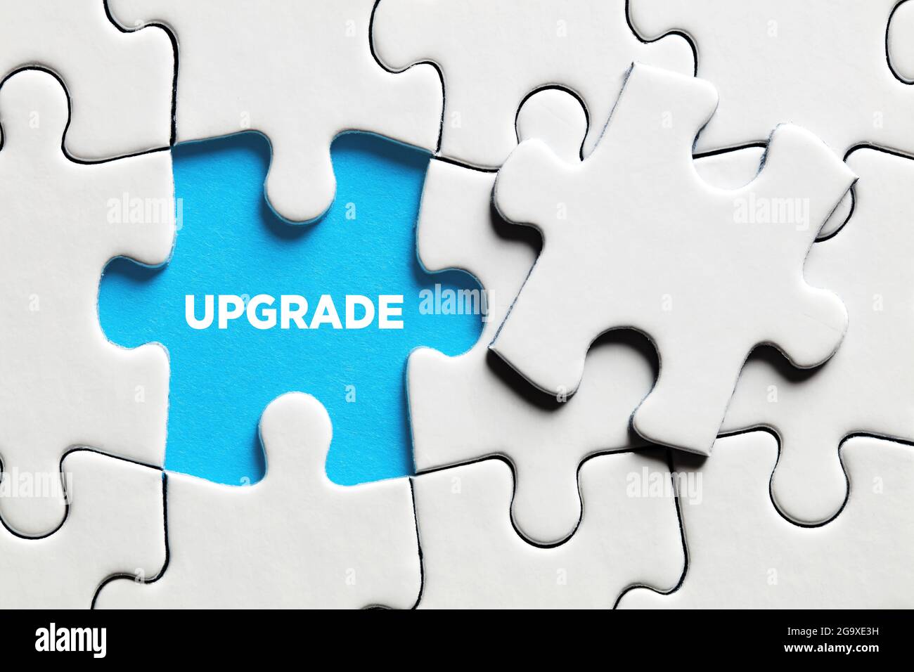 The word upgrade on a missing puzzle piece. To upgrade a software or hardware concept. Stock Photo