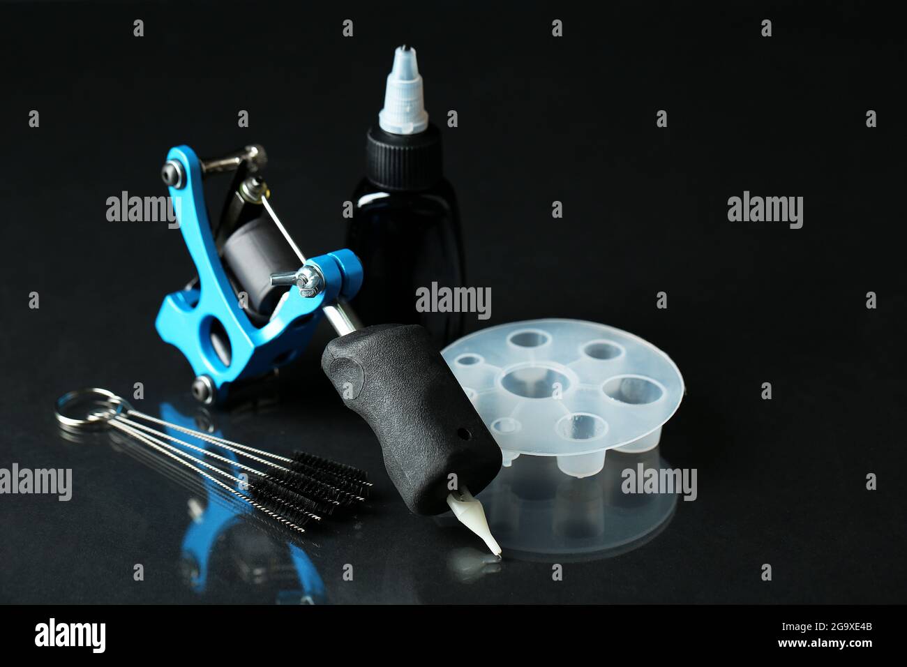 Tattoo machine and tattoo Supplies, on dark background Stock Photo - Alamy
