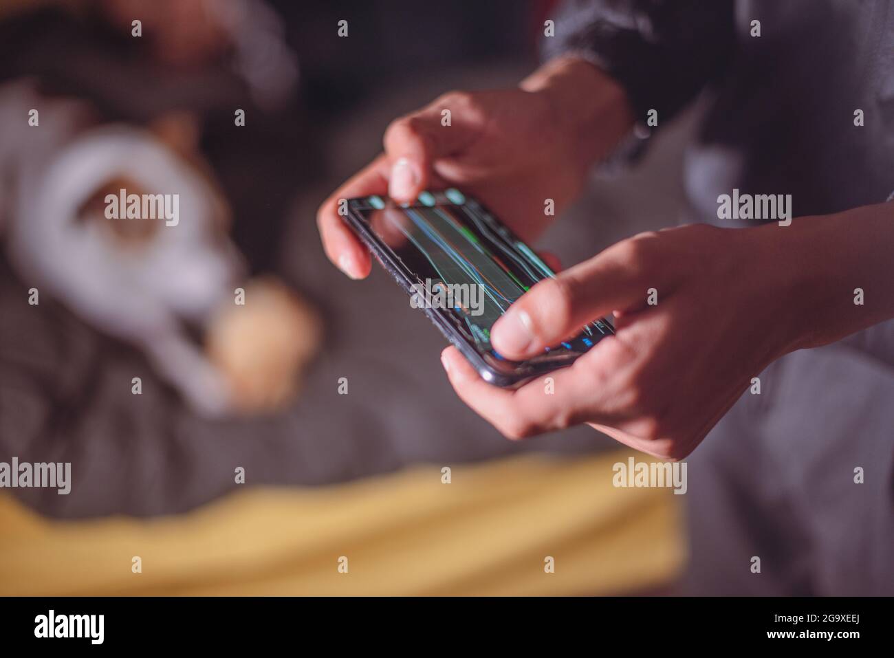 Person using mobile phone to trade in stock Stock Photo