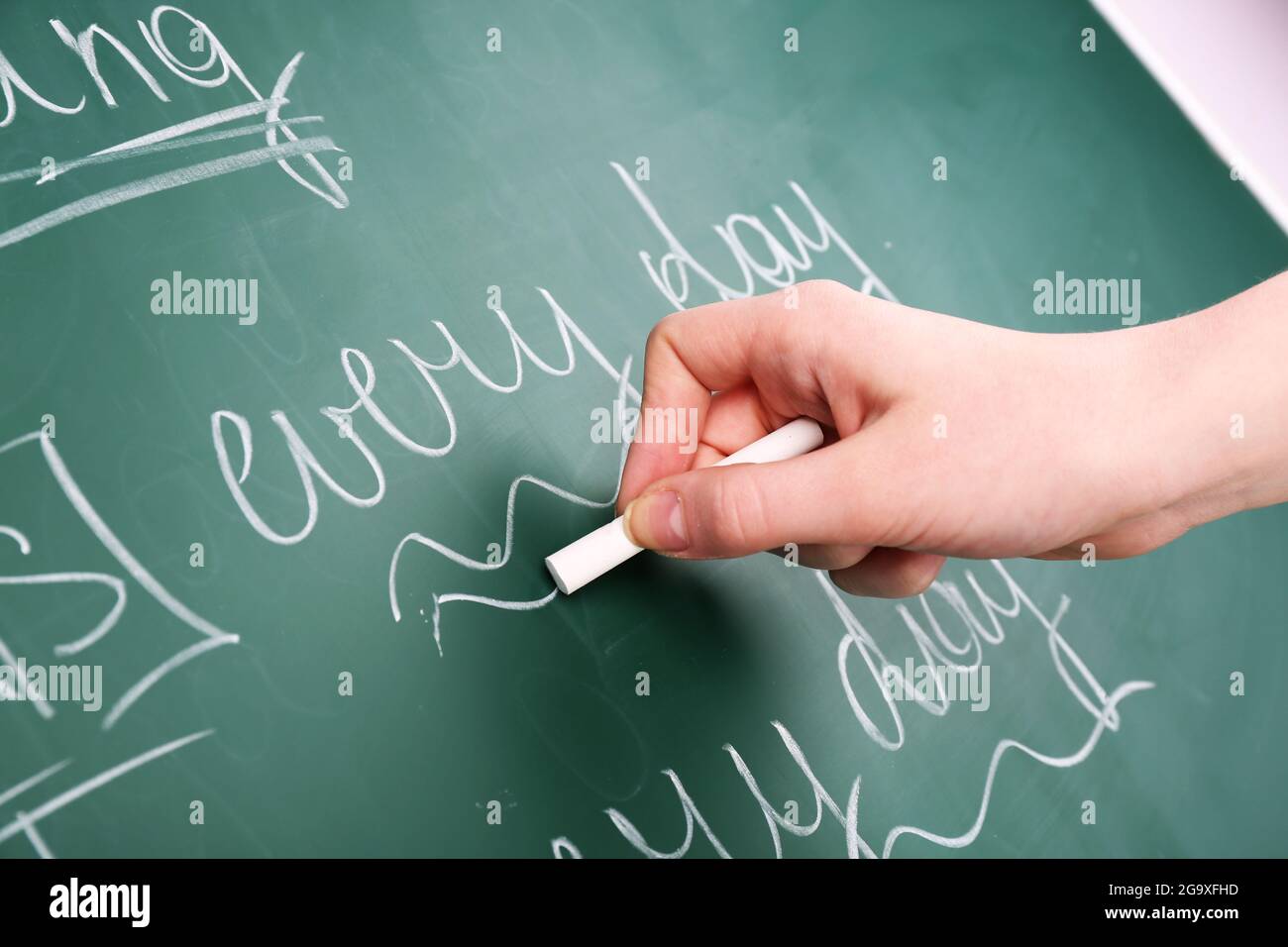Teacher hand writing grammar sentences on blackboard background Stock