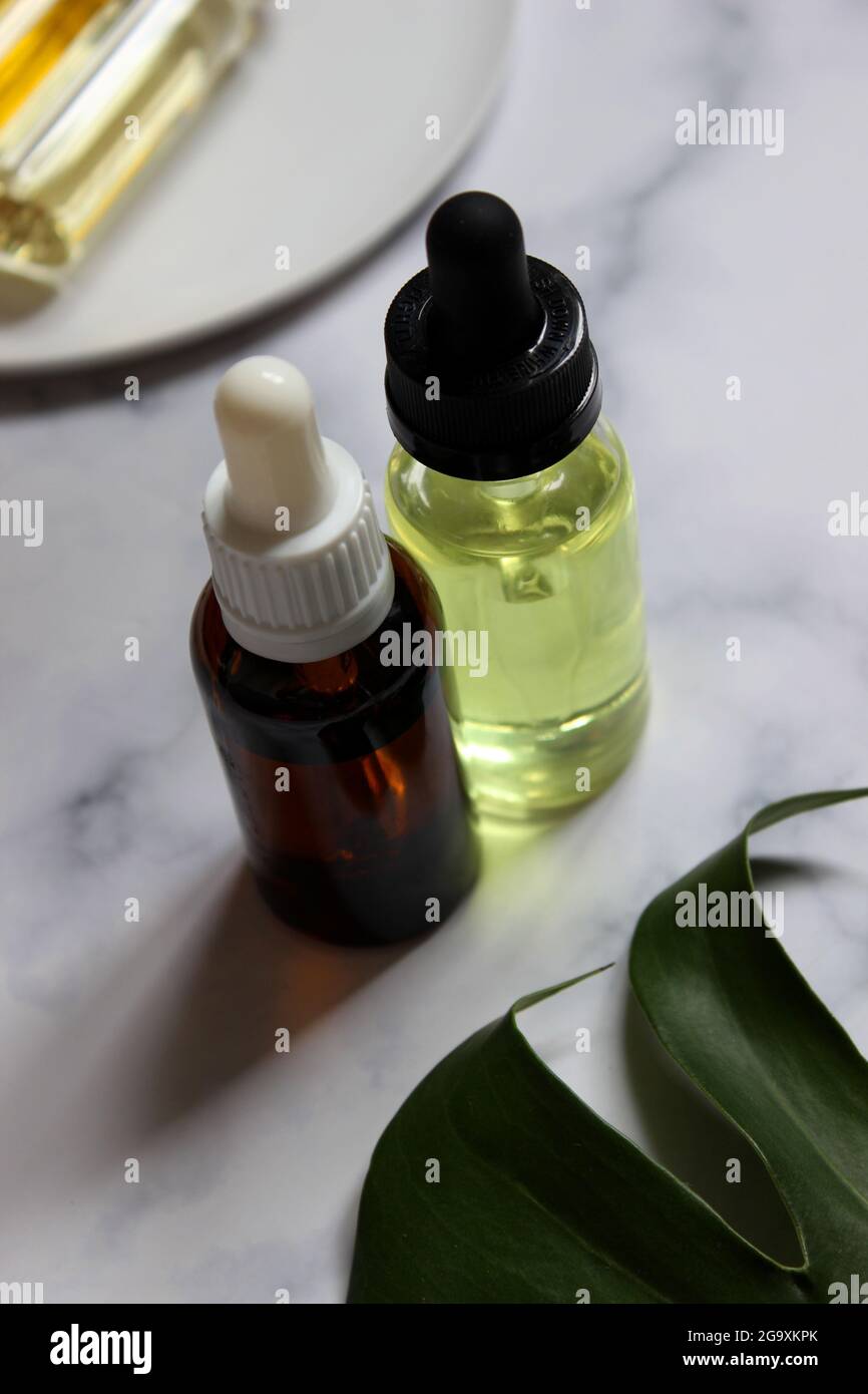 Essential oil bottle with fresh herbs. Massage oil for face and body. Relaxation. Stock Photo