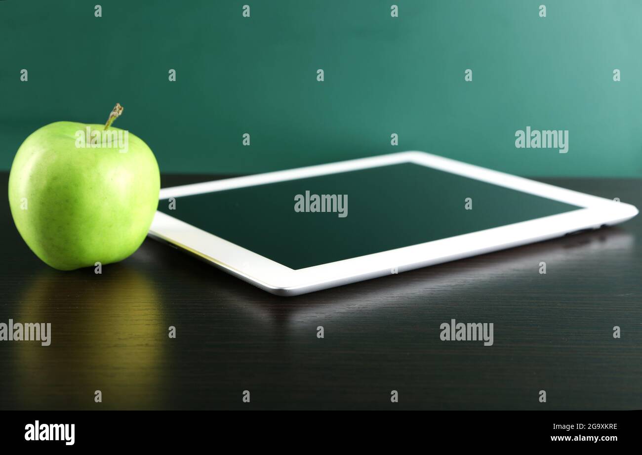 Digital tablet and apple on desk in front of blackboard Stock Photo Alamy