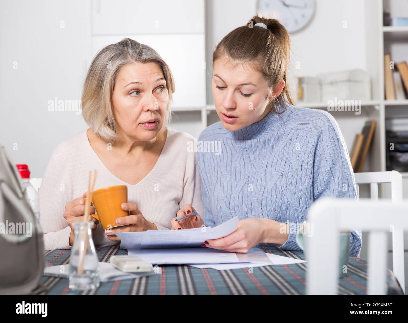 Woman and adult daughter fill out paperwork stock photo alamy