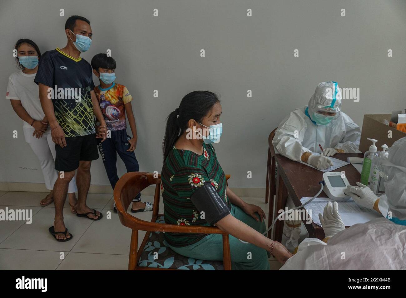 Badung, Indonesia. 27th July, 2021. Isolated patients get their routine medical check up at Wisma Bima Cottages II, Kuta. Bali local government has centralized Covid-19 isolations for asymptomatic and mild symptoms to make medical controlling easier. Before thousands of people were dying during self-quarantine in their own houses, based on Indonesia Health Ministry data. Credit: SOPA Images Limited/Alamy Live News Stock Photo