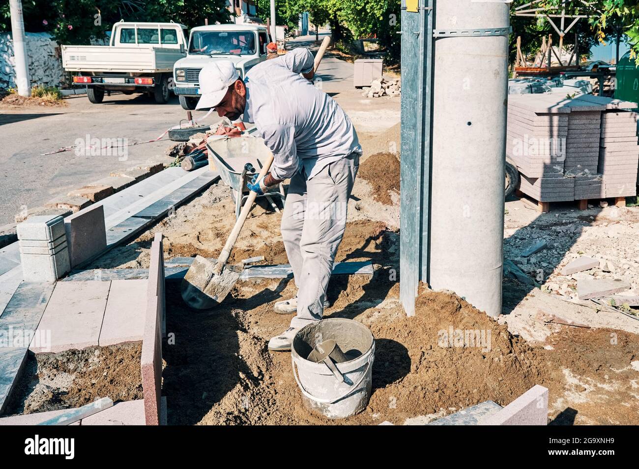 Worker using a shovel at the pavement construction site. Stock Photo