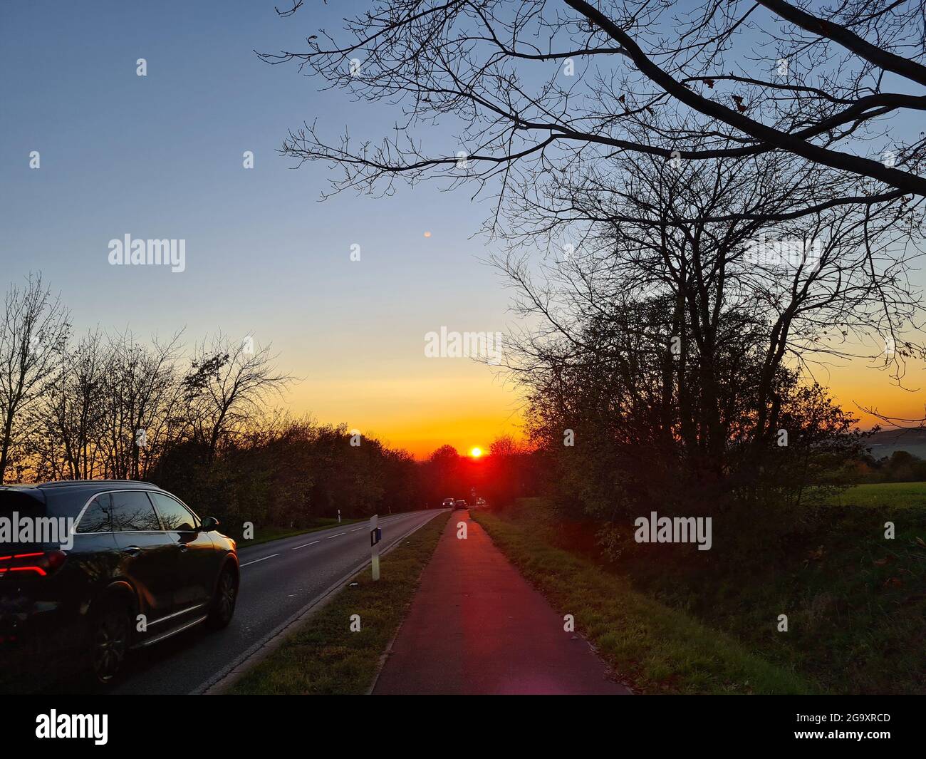 Highway traffic in sunset. Road with metal safety barrier or rail. cars on the asphalt under the cloudy sky. Stock Photo