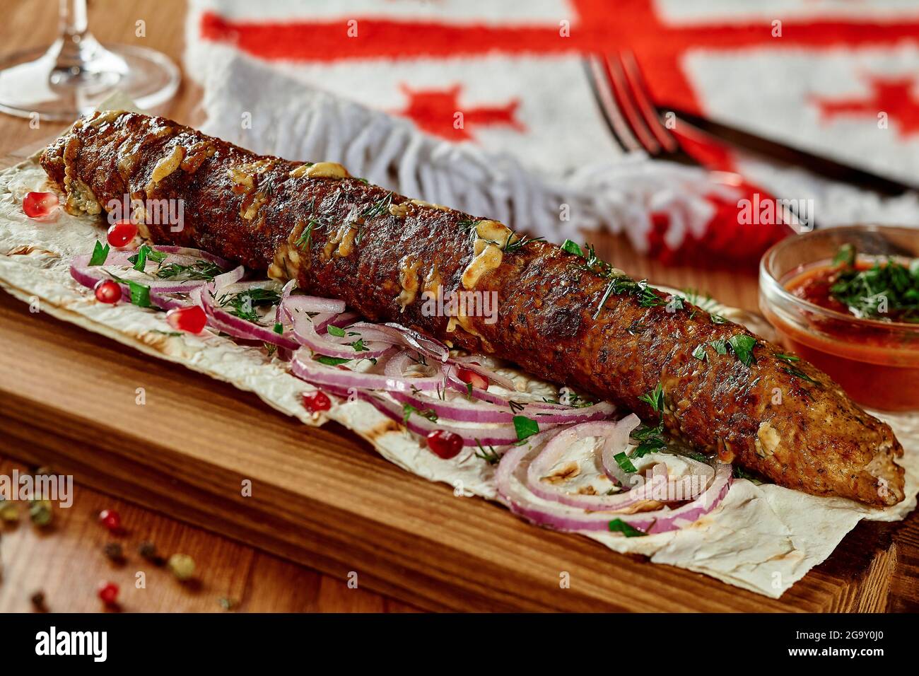 Beef and cheese kebab with lavash, onion, pomegranate seeds and