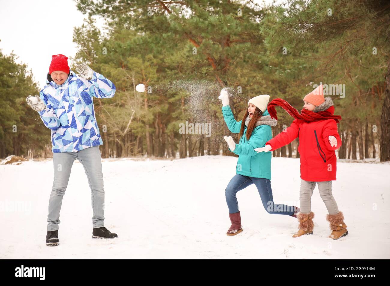 Happy family playing snowballs in park on winter day Stock Photo - Alamy
