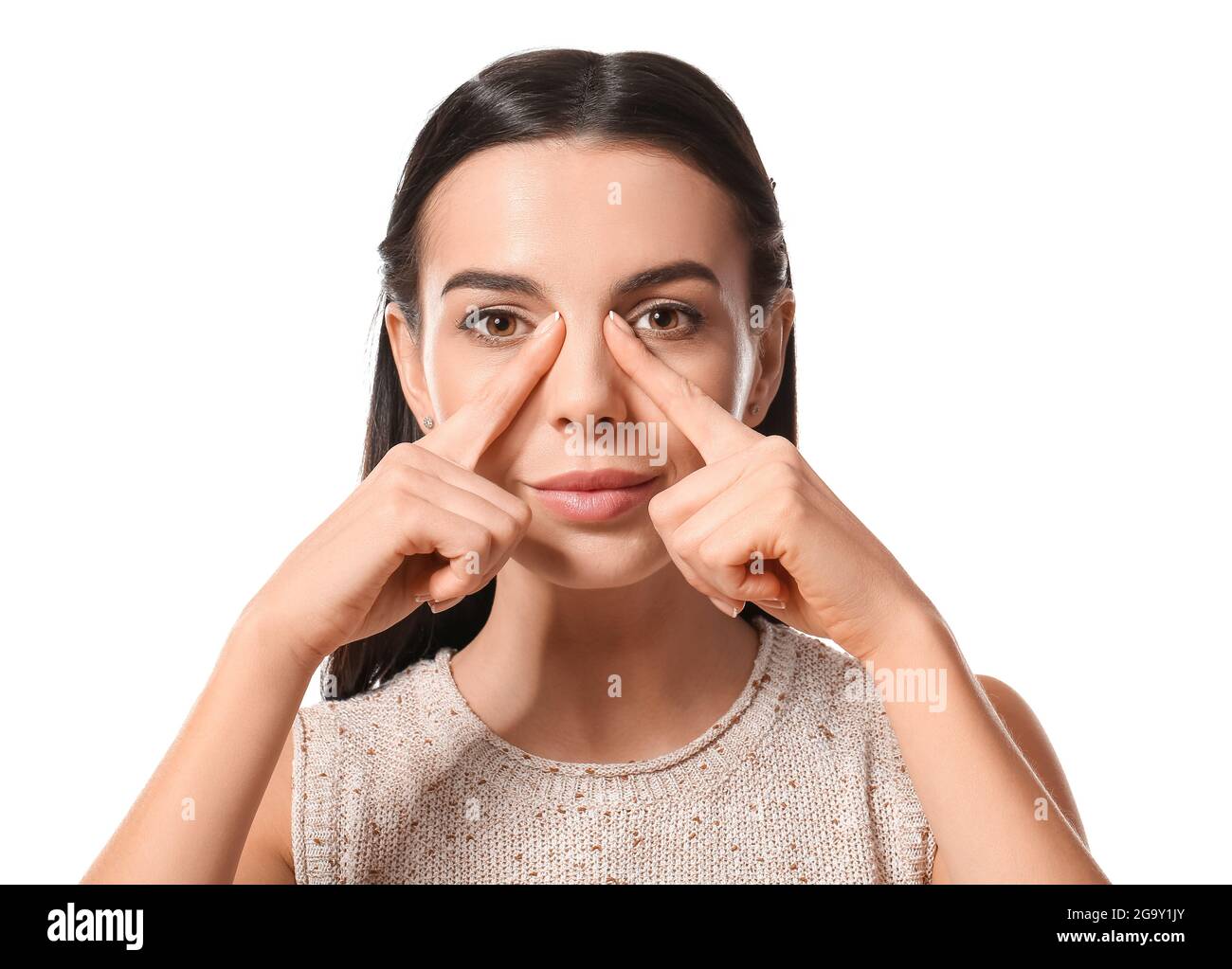Young woman doing face building exercise against white background Stock
