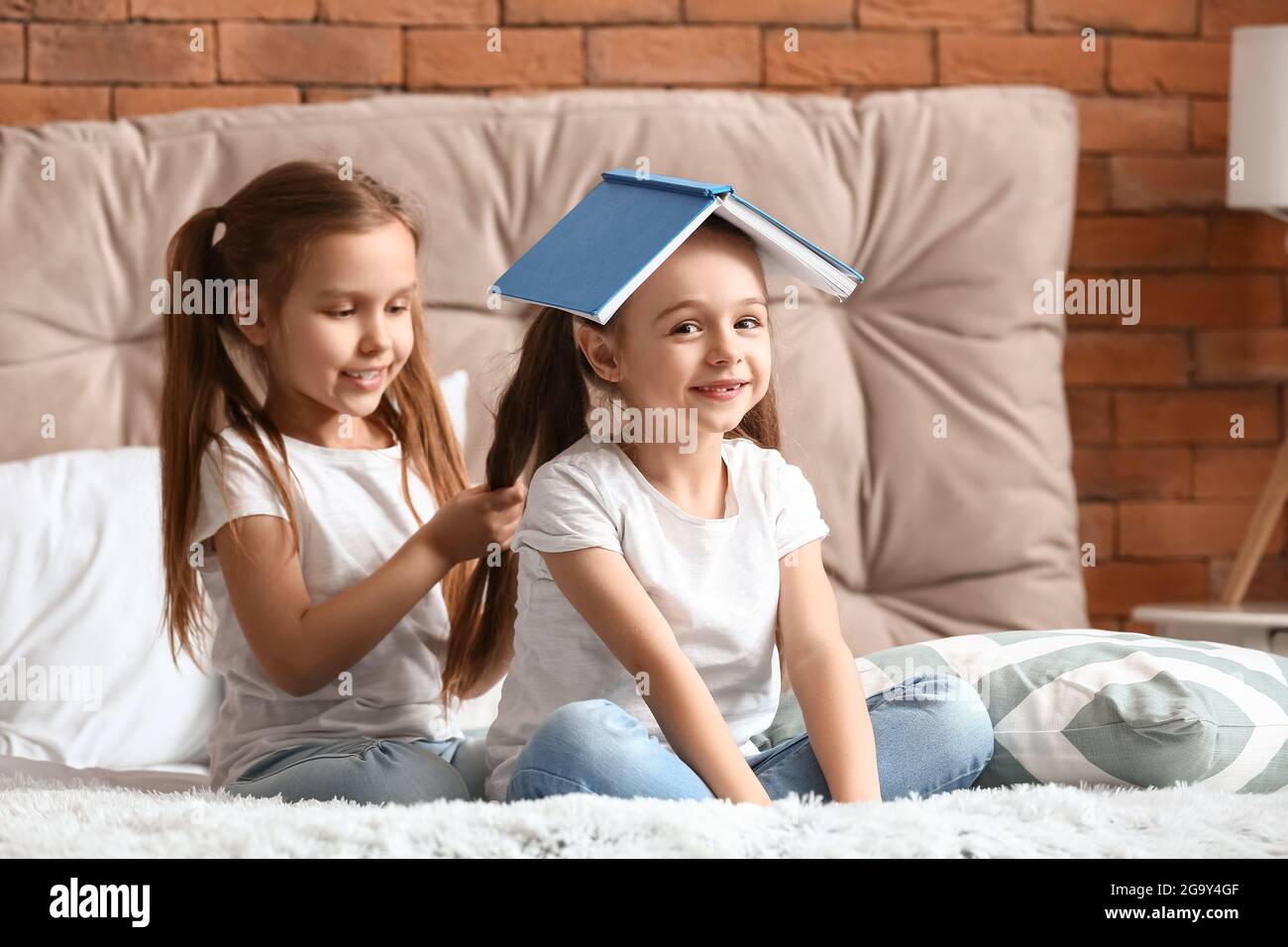 Cute little sisters having fun in bedroom Stock Photo - Alamy