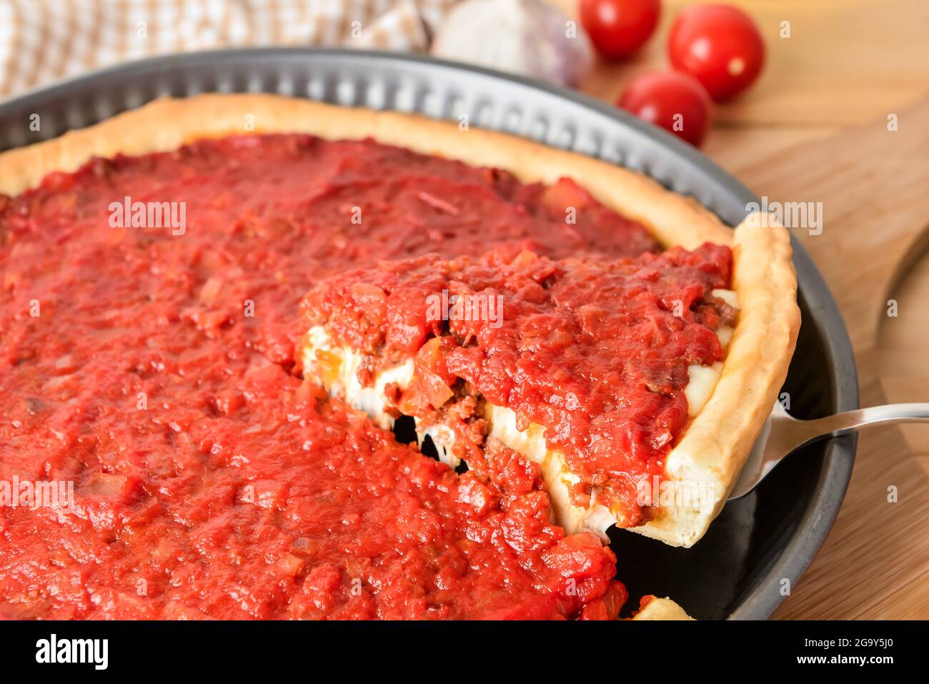 Baking dish with tasty Chicago-style pizza on table, closeup Stock Photo