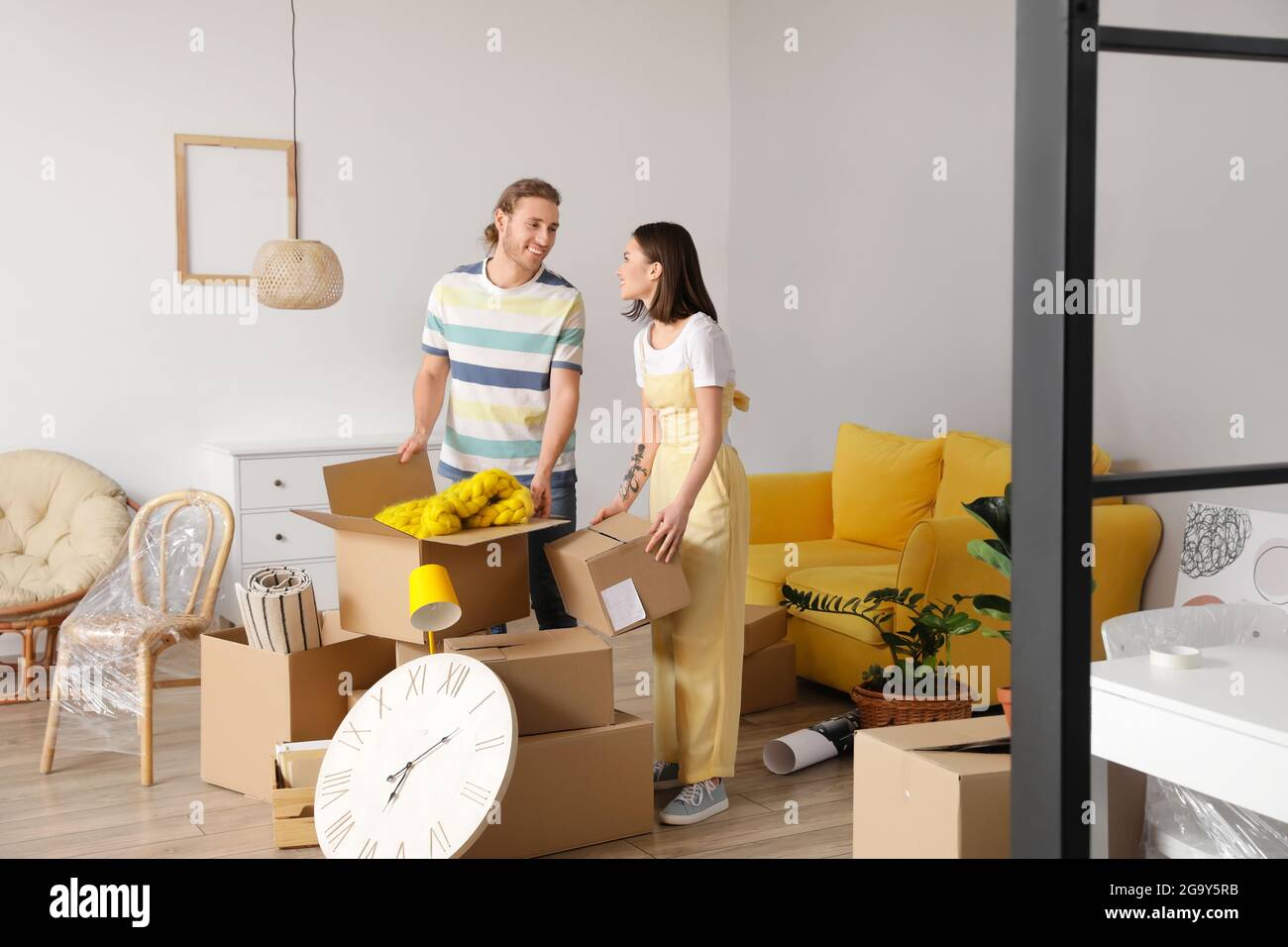 Young couple with cardboard boxes in their new house on moving day ...