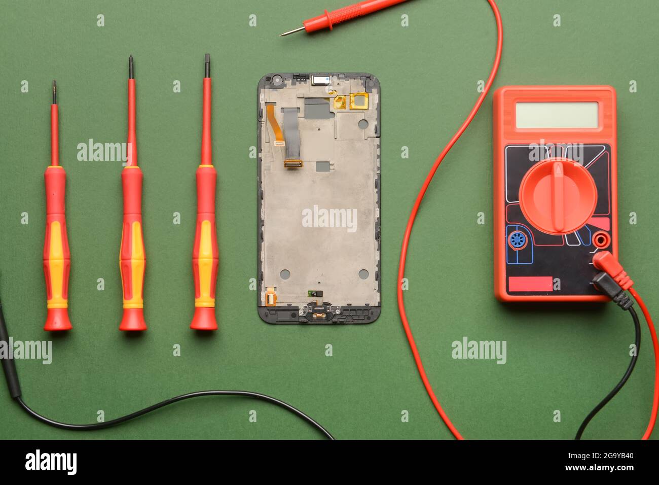 Disassembled mobile phone with technician tools on color background Stock Photo